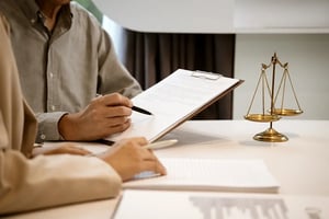 CyberGrant_Close-up of legal advisors analyzing paperwork in a law office meeting setting.